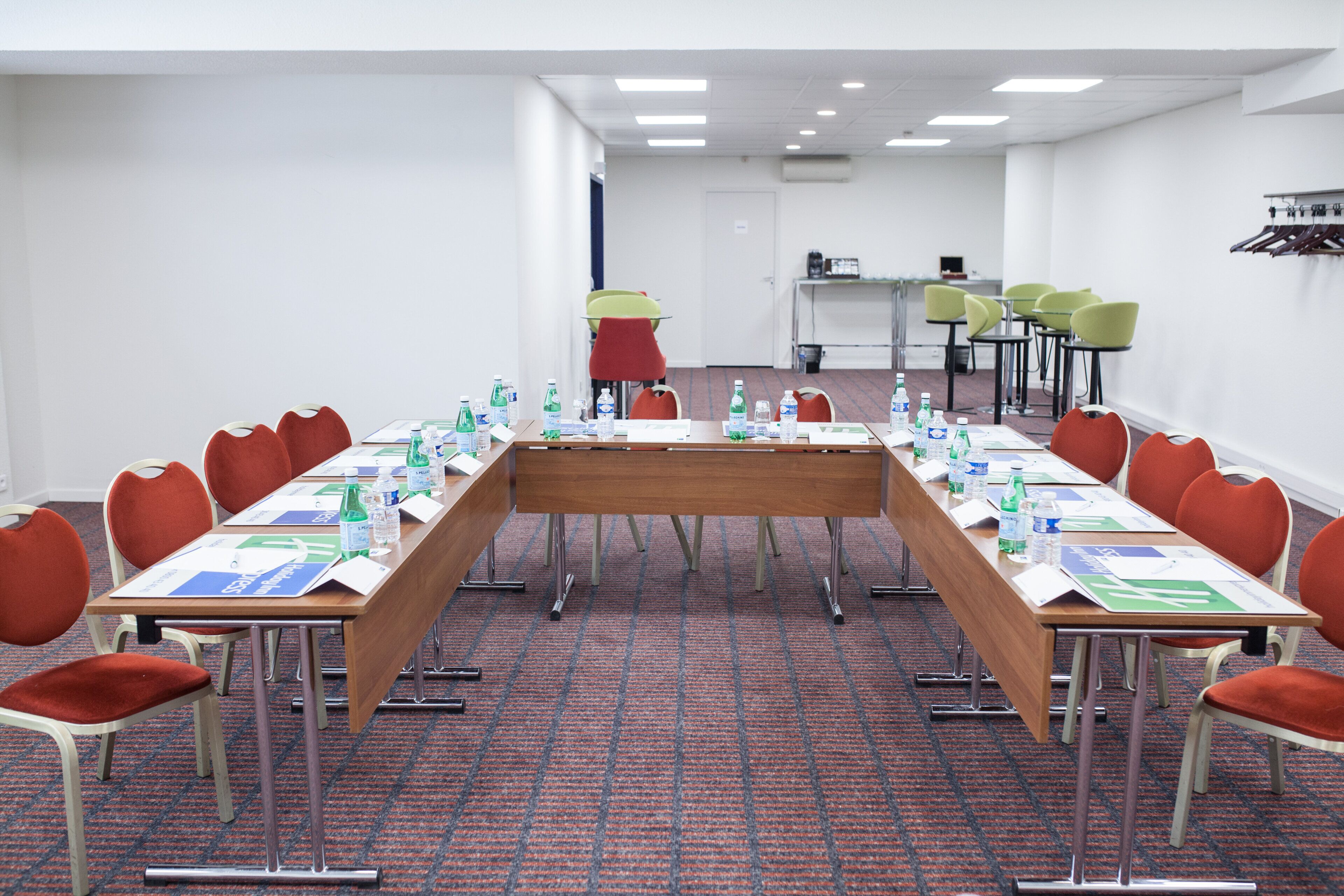 A conference room with a long table, chairs, and water bottles.