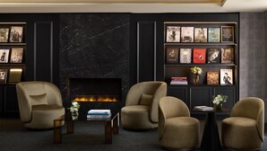 Un salón moderno con chimenea, asientos cómodos y una estantería con fotografías enmarcadas.