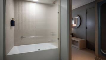 Een moderne badkamer met een bad, een douchecabine en een wastafel met spiegel.