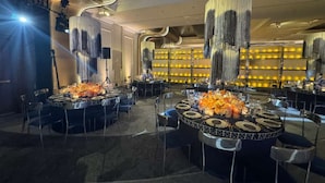 A restaurant with round tables, high ceilings, and modern lighting fixtures. - World of Blue (East Rutherford)