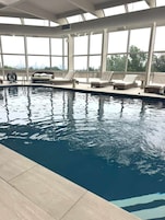 Una piscina interior con amplias vistas del horizonte urbano a través de grandes ventanales.