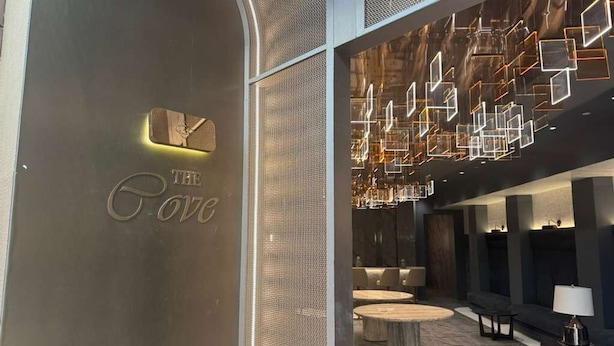 A modern lobby with a reception desk, seating area, and decorative lighting. - World of Blue (East Rutherford)