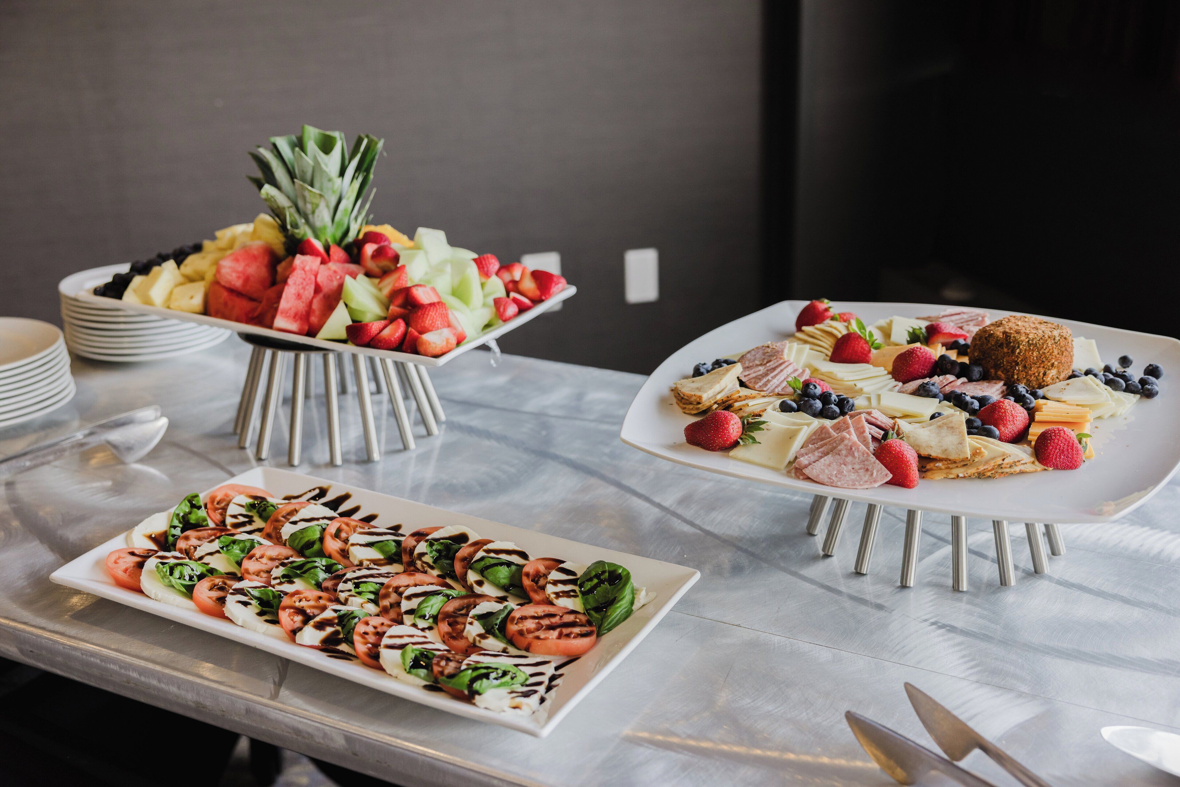 A buffet table with various food items including fruits, cheeses, and salads.
