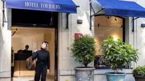 The entrance of Hotel Toujors with a modern facade, large potted plants, and a welcoming entrance. - Hôtel Toujours & Spa (Paris)