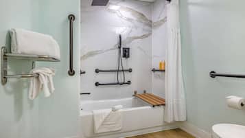 A bathroom with a shower, toilet, and two towel racks.