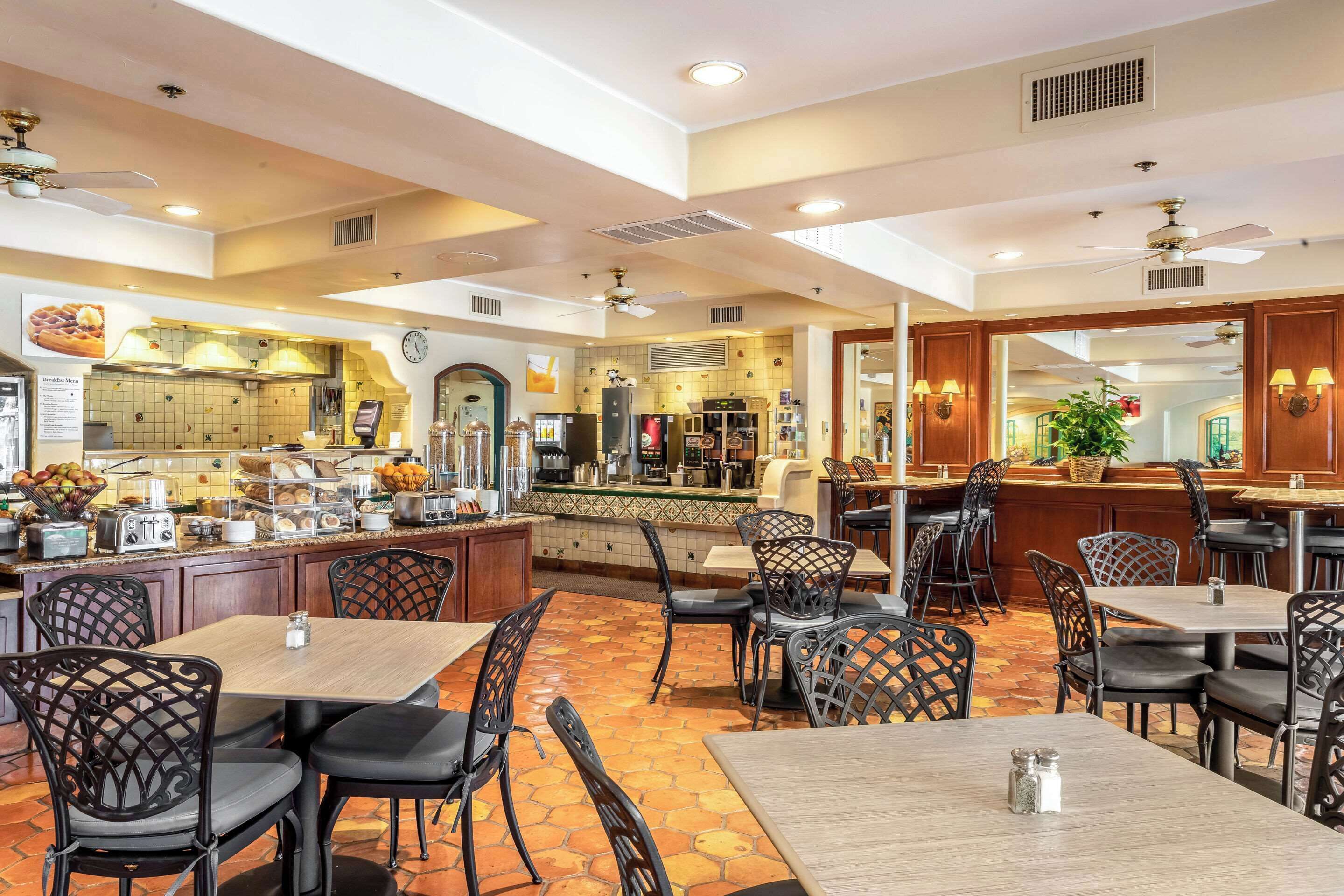 A spacious restaurant with high ceilings, multiple dining areas, and a visible kitchen area.