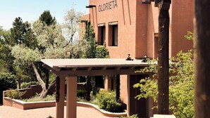 Un edificio con un letrero que dice "HOTEL GLORIETA" y una estructura de pérgola al frente.