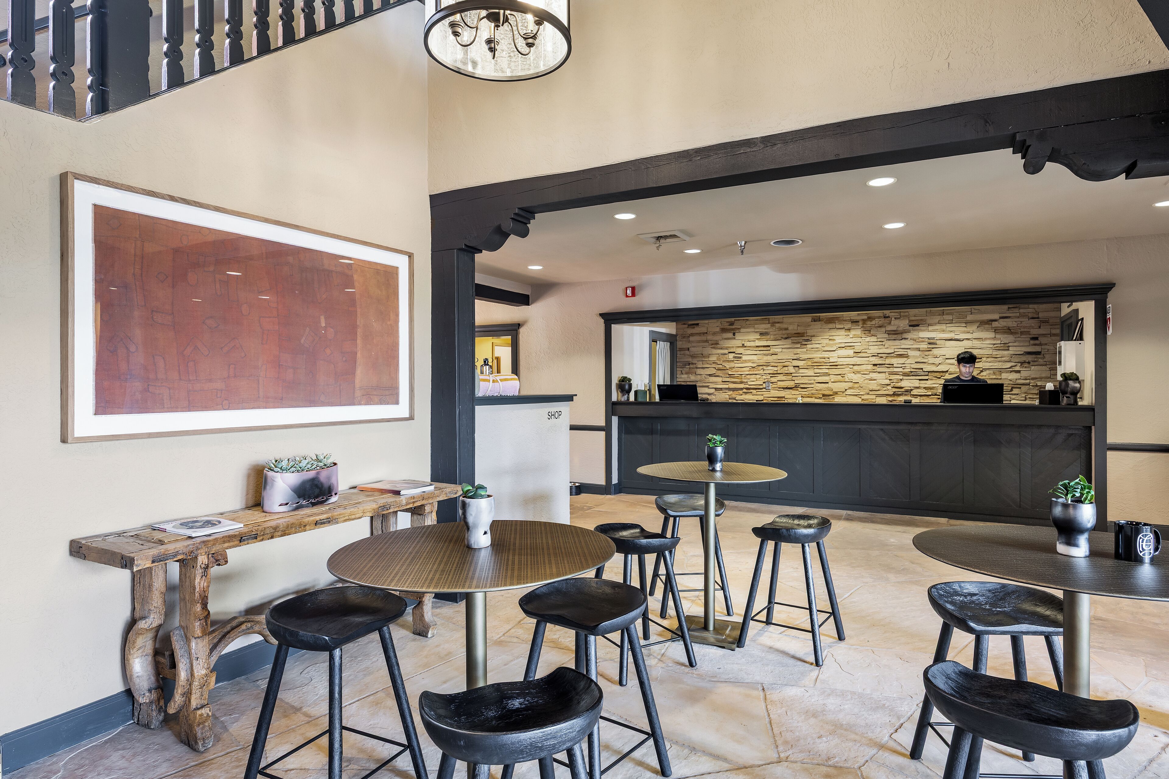 A modern interior with a bar area, seating, and a large abstract painting.