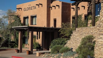A hotel named "Gloria" with a stucco exterior, stone walls, and a covered entrance area.