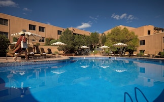 Una piscina al aire libre de temporada, sombrillas
