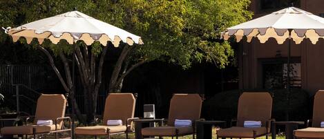 A poolside area with lounge chairs and umbrellas.