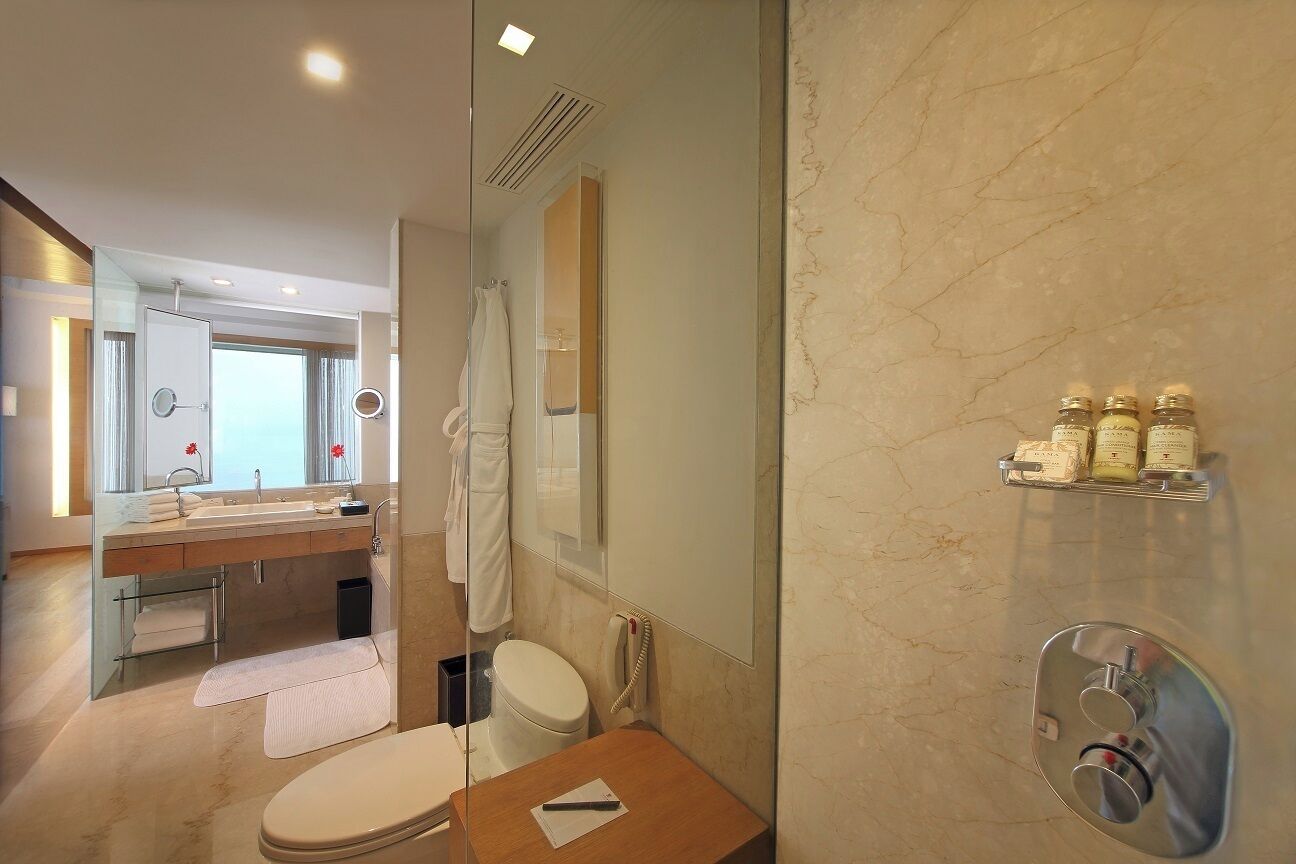 Un baño moderno con cabina de ducha de vidrio, tocador con espejo y retrete.