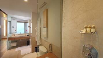 Un baño moderno con cabina de ducha de vidrio, tocador con espejo y retrete.