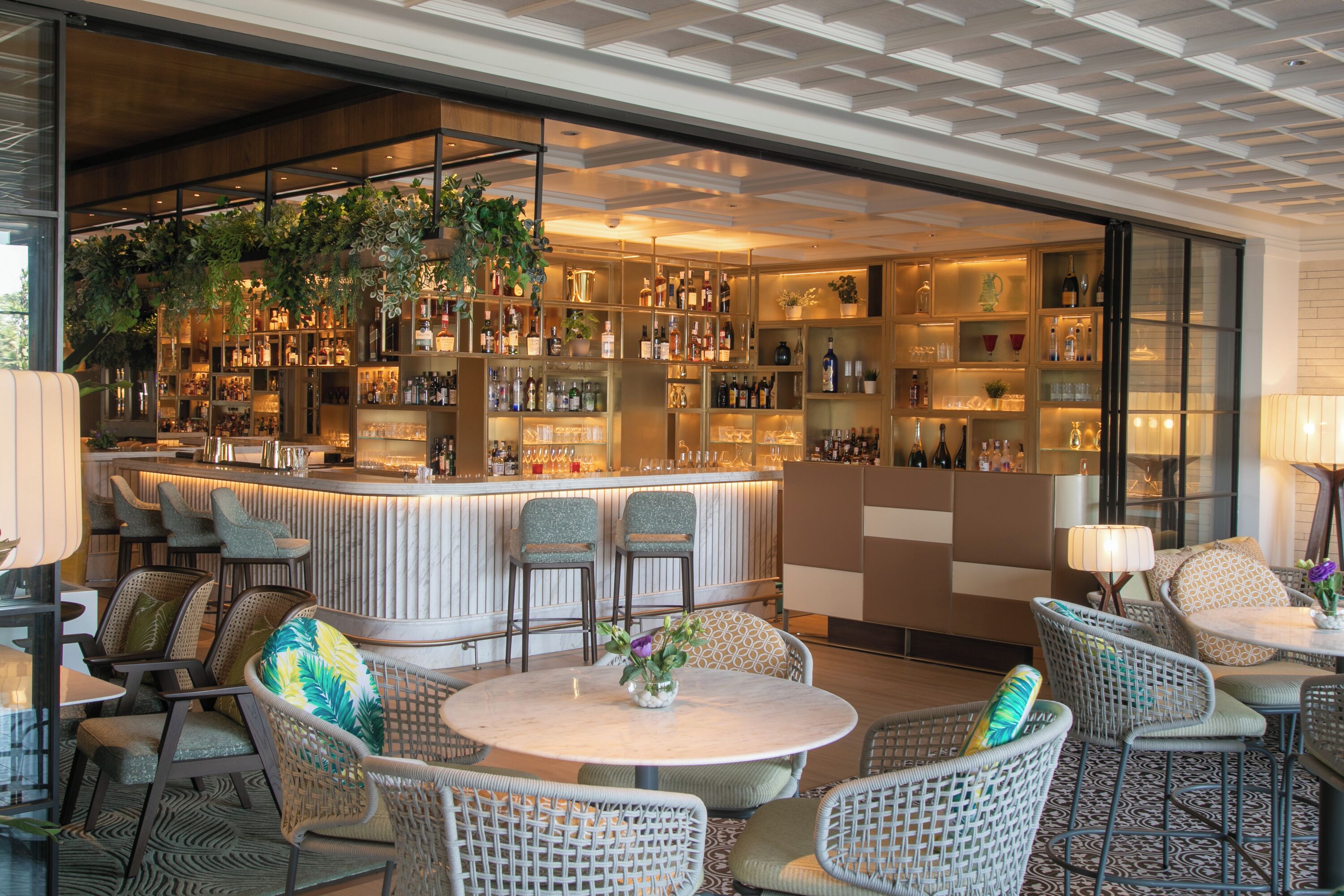 A bar area with seating, a bar counter, and shelves with bottles.