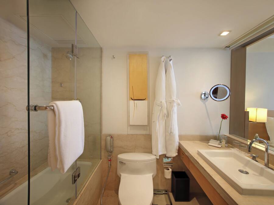 A modern bathroom with a glass-enclosed shower, a white toilet, a sink with a mirror, and a towel rack.