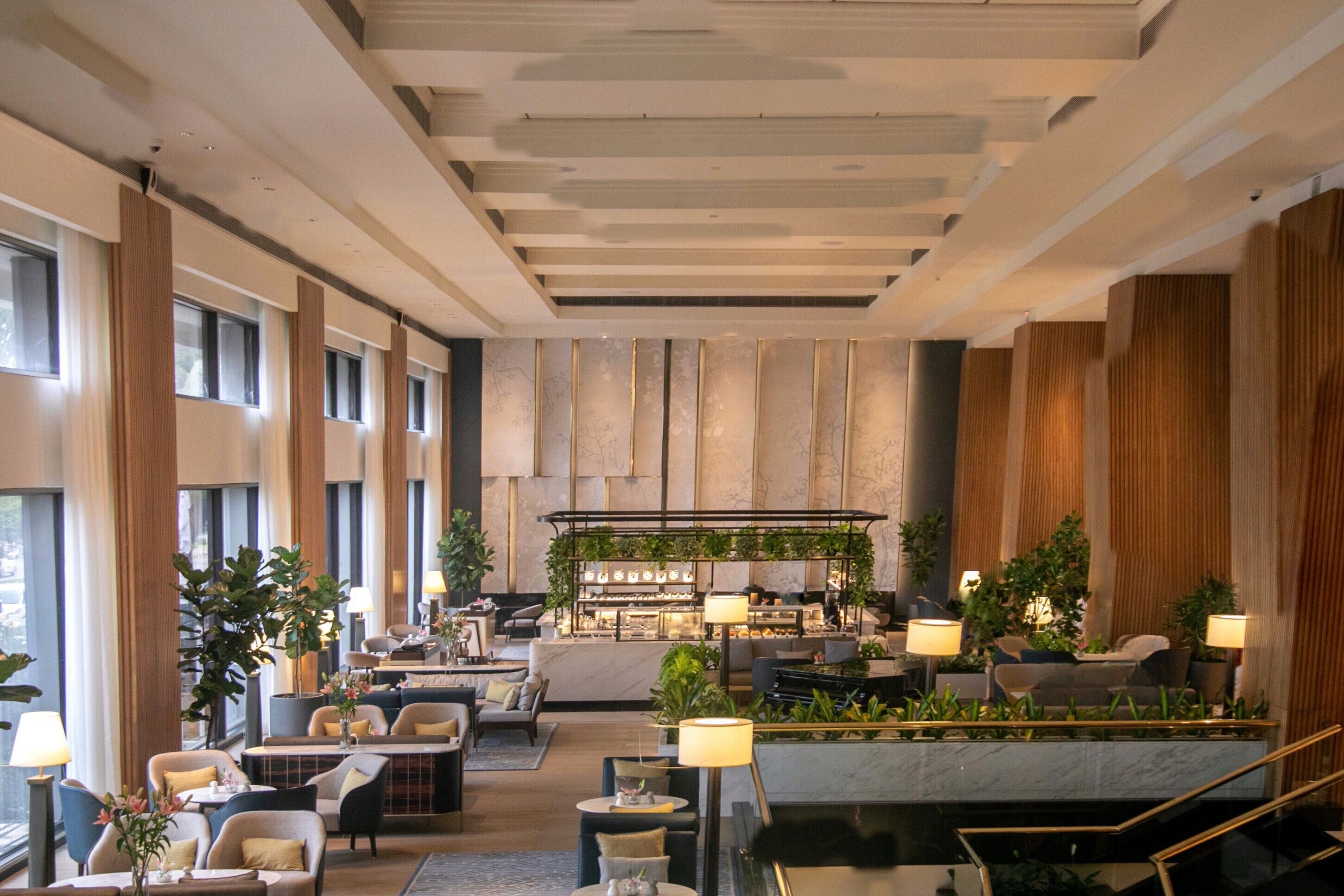 A spacious lobby with seating areas, a bar, and a staircase.