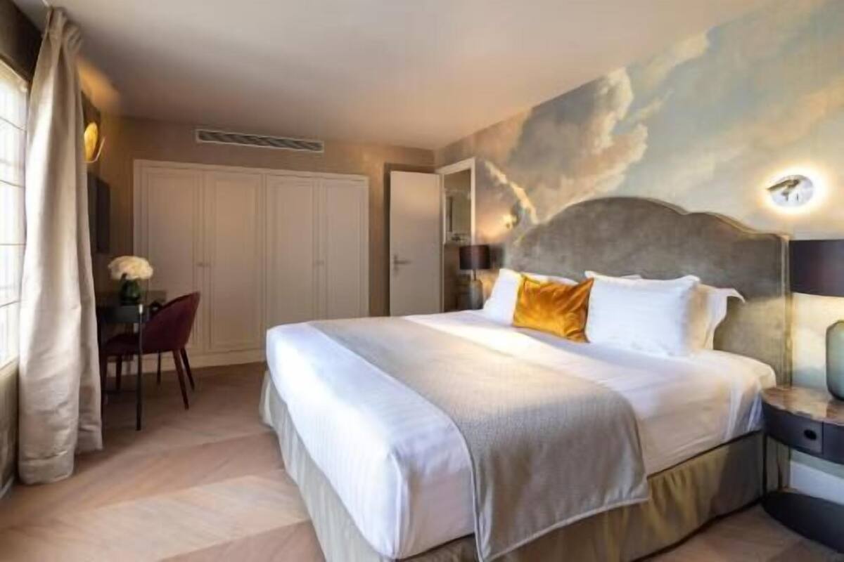 Une chambre d’hôtel avec un grand lit, un bureau et une chaise.
