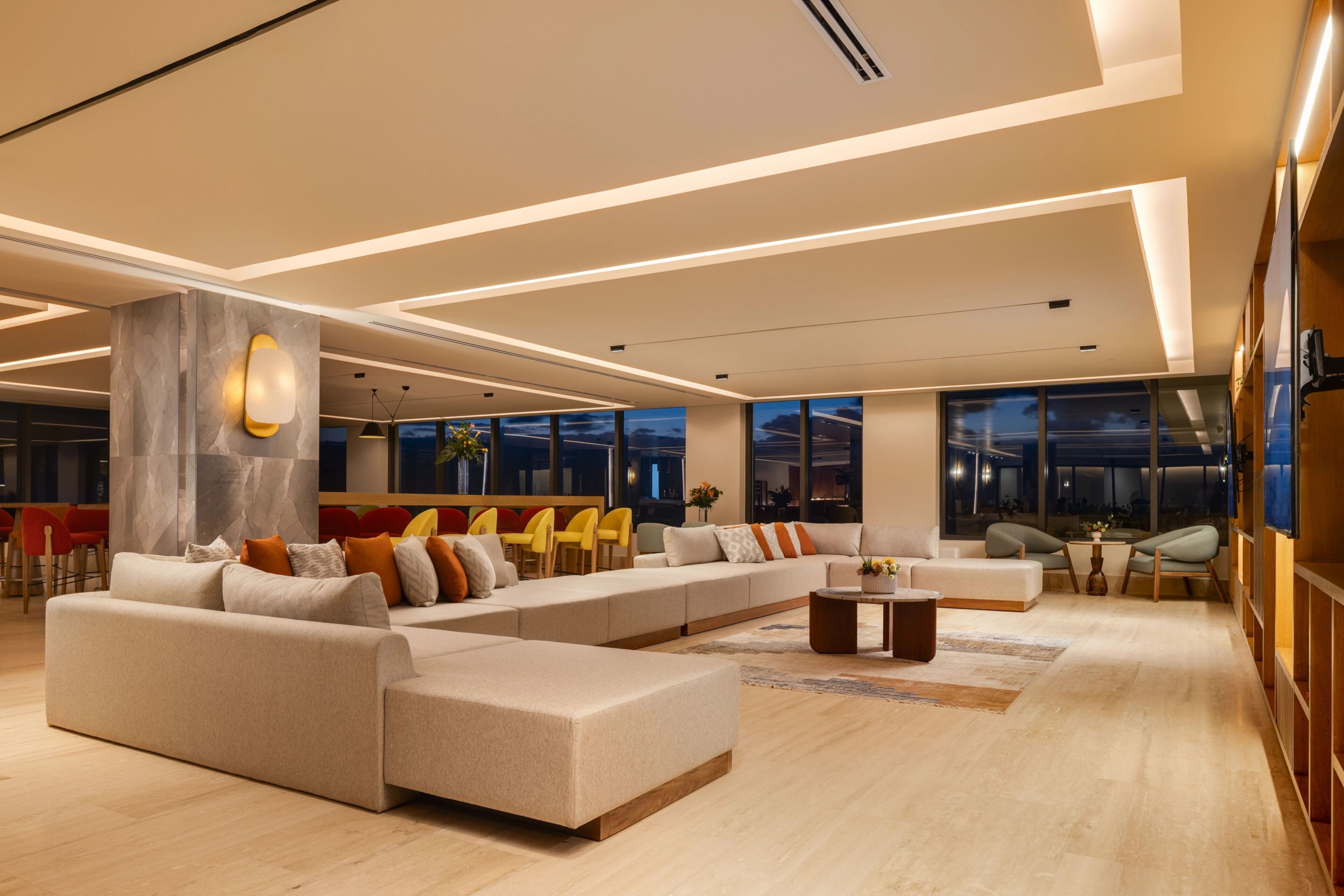 A spacious living area with a large sectional sofa, a coffee table, and a seating area with chairs.