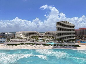Een resort met meerdere gebouwen, een strand en een zwembad.