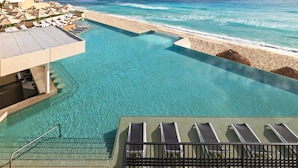 A resort pool with a view of the beach and ocean.