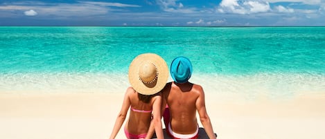 Aan het strand, wit zand, parasols, strandlakens
