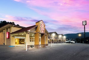 A Red Roof Inn with a brick facade and a large illuminated sign.