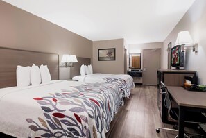A hotel room with a large bed, bedside lamps, a desk with a television, and a bathroom visible in the background. - Red Roof Inn Chattanooga - Lookout Mountain (Chattanooga)
