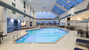 Una piscina interior con indicaciones claras para zonas sin saltos y zonas de salto, rodeada de sillones y mesas.