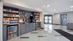 A modern hotel lobby with a reception desk, self-service beverage machine, and a refrigerated display. - Best Western Morton Inn (Morton)