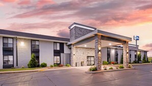 A modern hotel with a stone facade, a covered entrance, and a sign indicating it is a Best Western property.