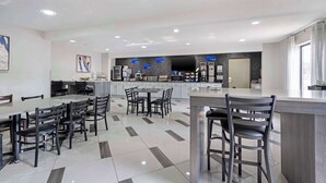 A modern kitchen with a central island, a dining area with chairs, and a bar area with stools. - Best Western Morton Inn (Morton)