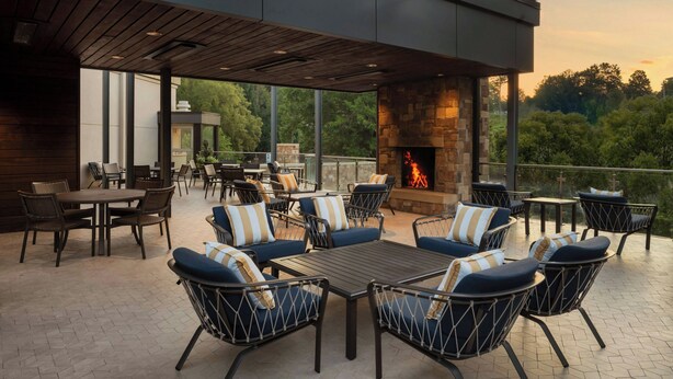 An outdoor patio with seating, a fire feature, and a view of the surrounding area.