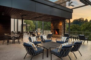 Un patio exterior con mobiliario, una chimenea y vistas del entorno.