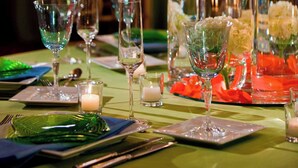 A table set for a formal dining event with clear glassware, candles, and floral arrangements.