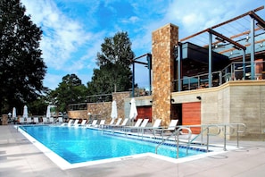 Alberca al aire libre, sombrillas en la alberca y camastros