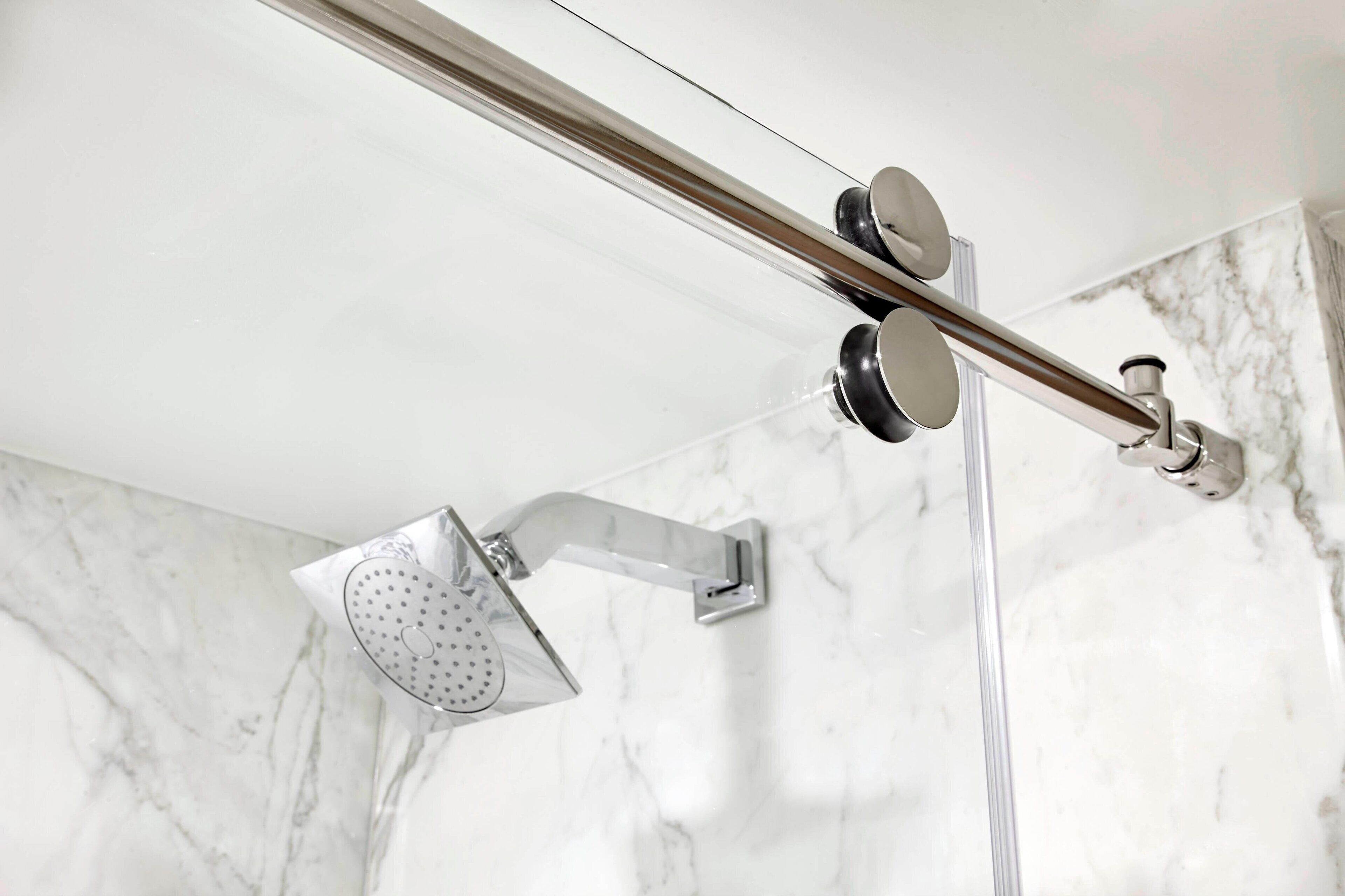 A modern shower with a handheld showerhead and a wall-mounted control panel.