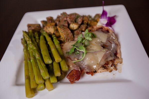 A plate with asparagus, roasted potatoes, and a piece of meat with a garnish.
