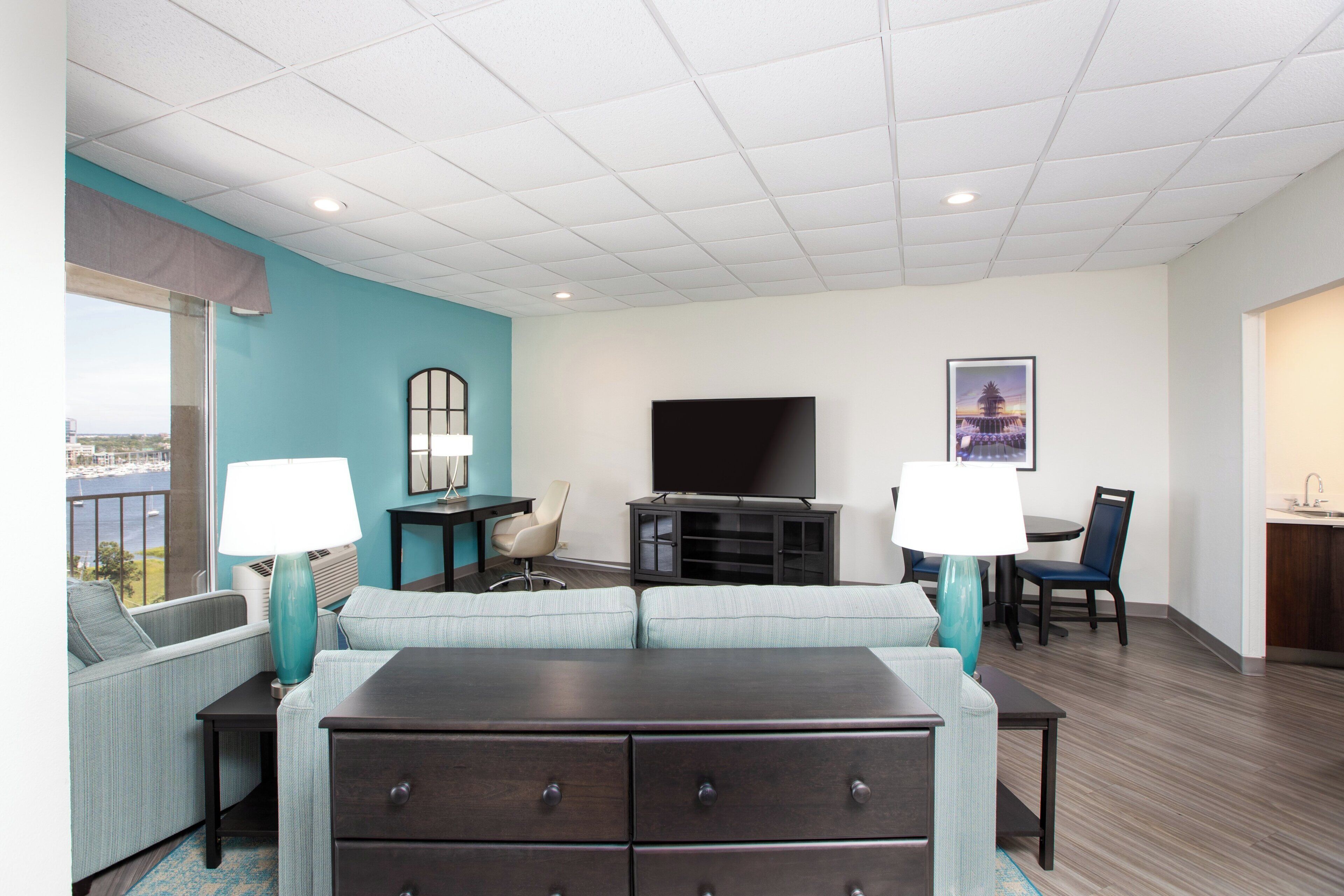 A hotel room with a large bed, a TV, a desk, and a chair.