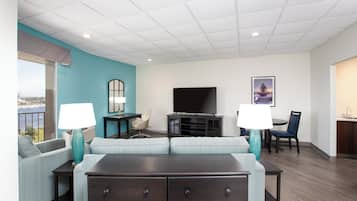 A hotel room with a large bed, a TV, a desk, and a chair.