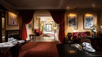 Een hotel lobby met een receptiebalie, een zithoek en kunstwerken aan de muren.