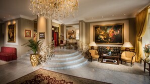 A grand lobby with a marble staircase, a chandelier, and a large classical painting. - Bristol Hotel Salzburg (Salzburg)