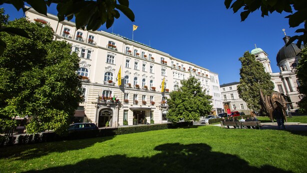 A large, historic building with a central entrance, surrounded by well-maintained lawns and trees. - Bristol Hotel Salzburg (Salzburg)