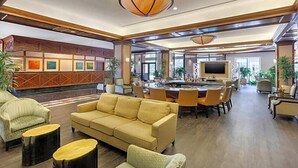 A spacious lobby with a sofa, armchairs, a dining area, and a TV. - Austin Southpark Hotel (Austin)