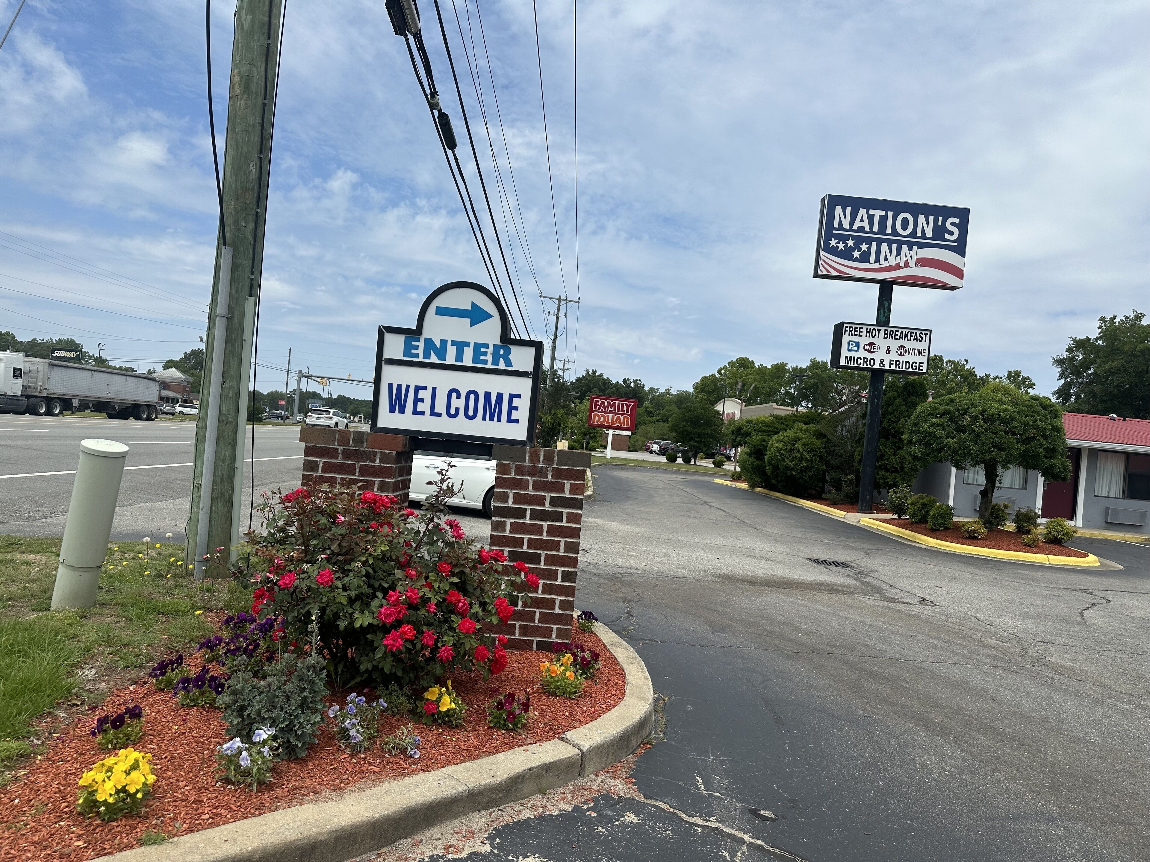 A roadside sign with "ENTER WELCOME" and "NATION'S INN" indicating a motel.
