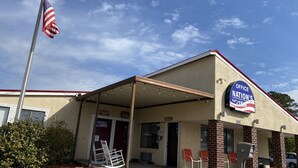 A building with a sign reading "Office Nation's Inn" and a flagpole with an American flag. - Nation's Inn Kinston (Kinston)