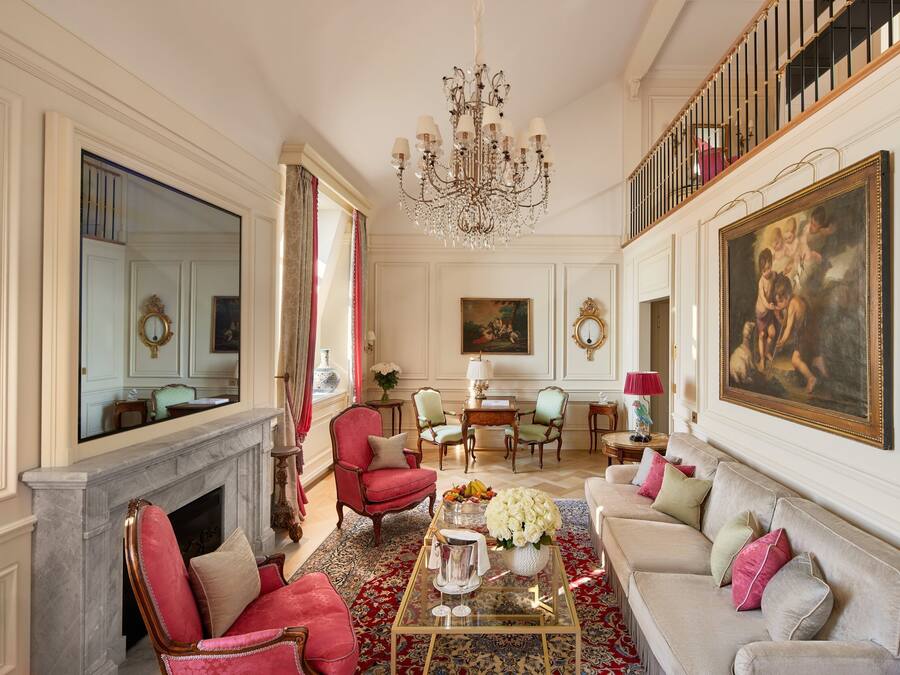 Un salón amplio con chimenea, muebles elegantes y una araña.