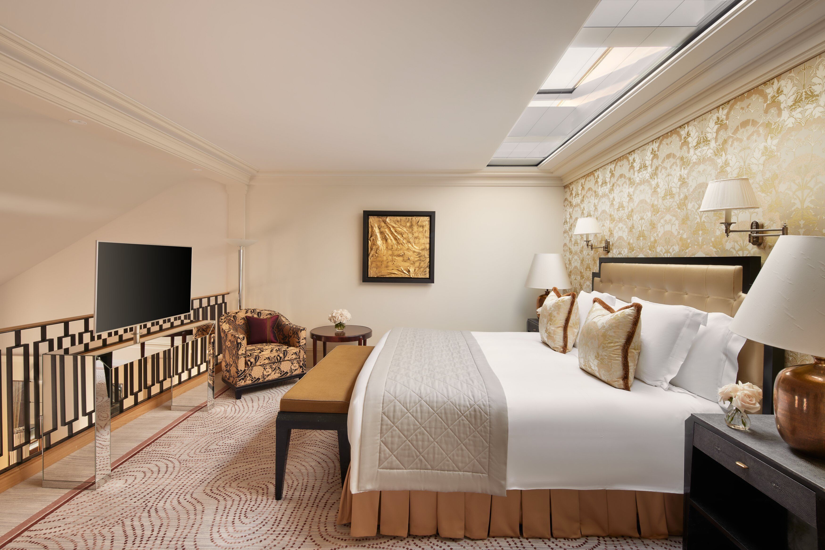 A hotel room with a large bed, a TV, a desk, and a chair.