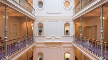 A multi-level interior with ornate railings and a central open space.