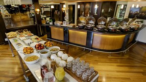 Un montaje tipo bufé con diversas opciones de comida y bebidas, una barra con equipo de cocina y un suelo de madera.