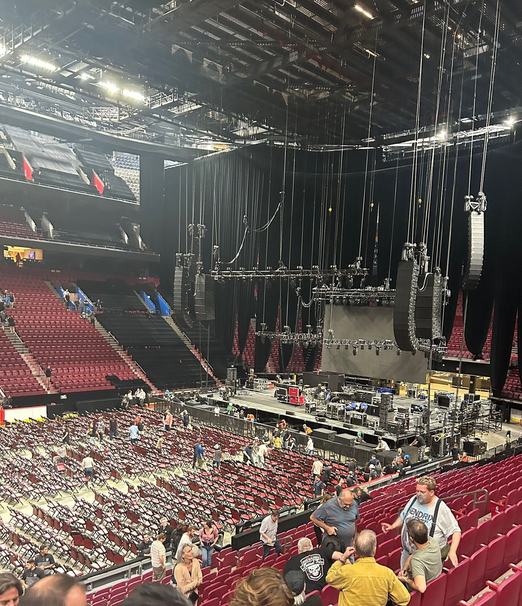 Un estadio interior grande con varios niveles de asientos, un escenario y diverso equipamiento técnico.